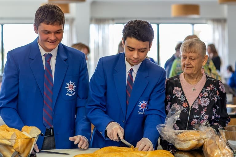 Aquinas College students serving meals to the community